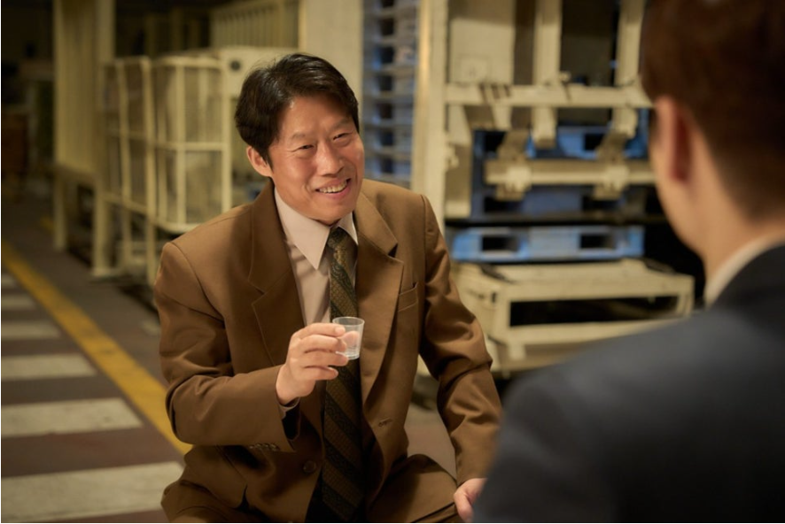 종록이 인범을 앞에두고 술잔을 들고 기뻐하는 모습.