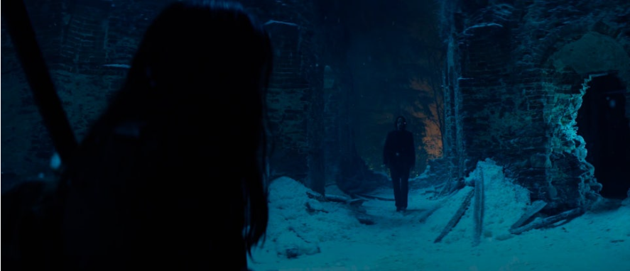 이미지는 영화 **《발레리나》**의 스틸컷입니다. 눈 덮인 어두운 동굴 같은 공간에서, 루니(아나 데 아르마스)가 실루엣으로 보이고 그 앞쪽으로는 존 윅(키아누 리브스)이 걸어오는 모습입니다. 이 장면은 두 인물이 협력을 시작하거나 중요한 대면을 하는 순간을 포착한 것으로 보입니다.