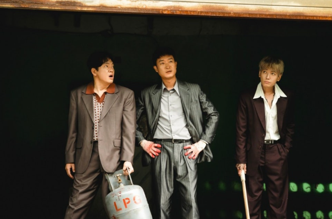 영화 **'보스(BOSS)'**에서 세 명의 주인공이 어두운 공간 속에서 무언가를 맞닥뜨린 듯한 긴장된 순간을 담고 있습니다.