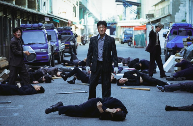 영화 **'보스(BOSS)'**에서 액션과 코미디가 결합된 영화의 성격을 극명하게 보여주는 역동적인 장면입니다.