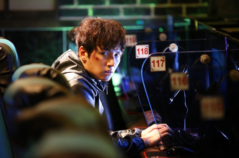 영화 **'조작된 도시'**의 한 장면으로, 주인공 권유(지창욱 분)가 처한 긴박한 상황을 보여줍니다.